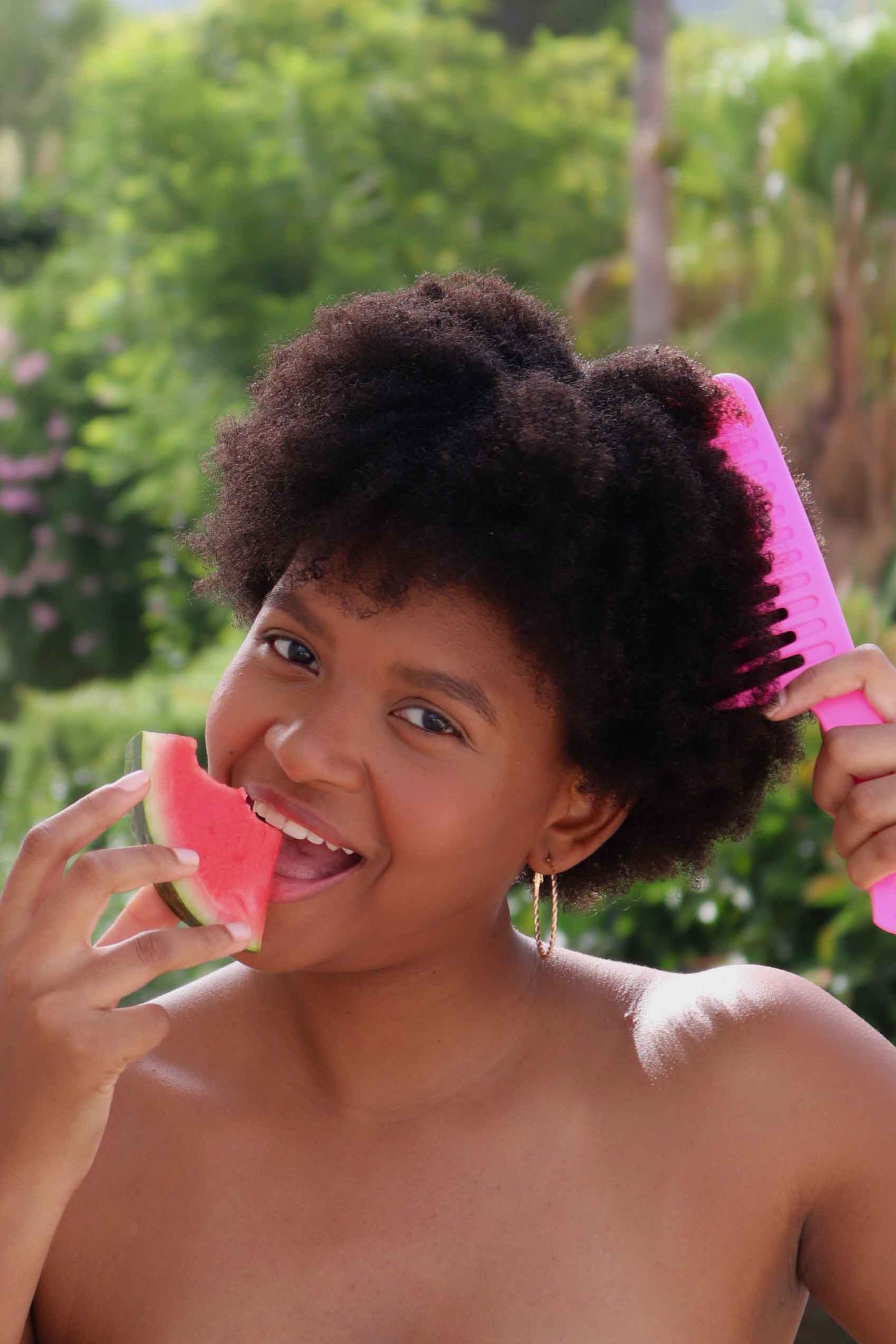 Frau mit Afrohaar pflegt ihre Naturlocken auf natürliche Weise – Lebensfreude und Natürlichkeit bei Germanya Naturkosmetik